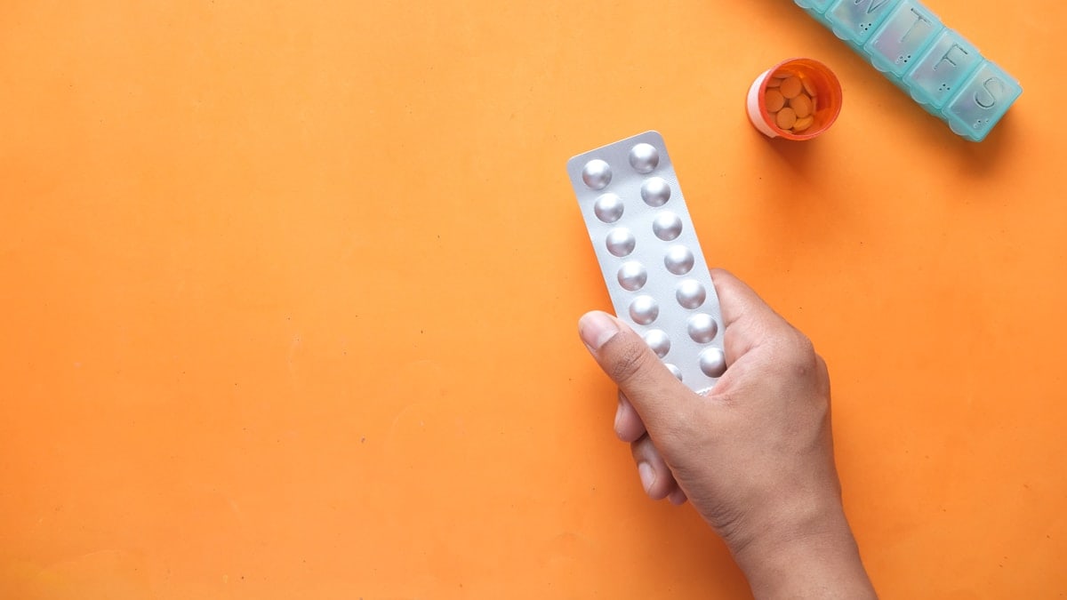 person holding white blister pack